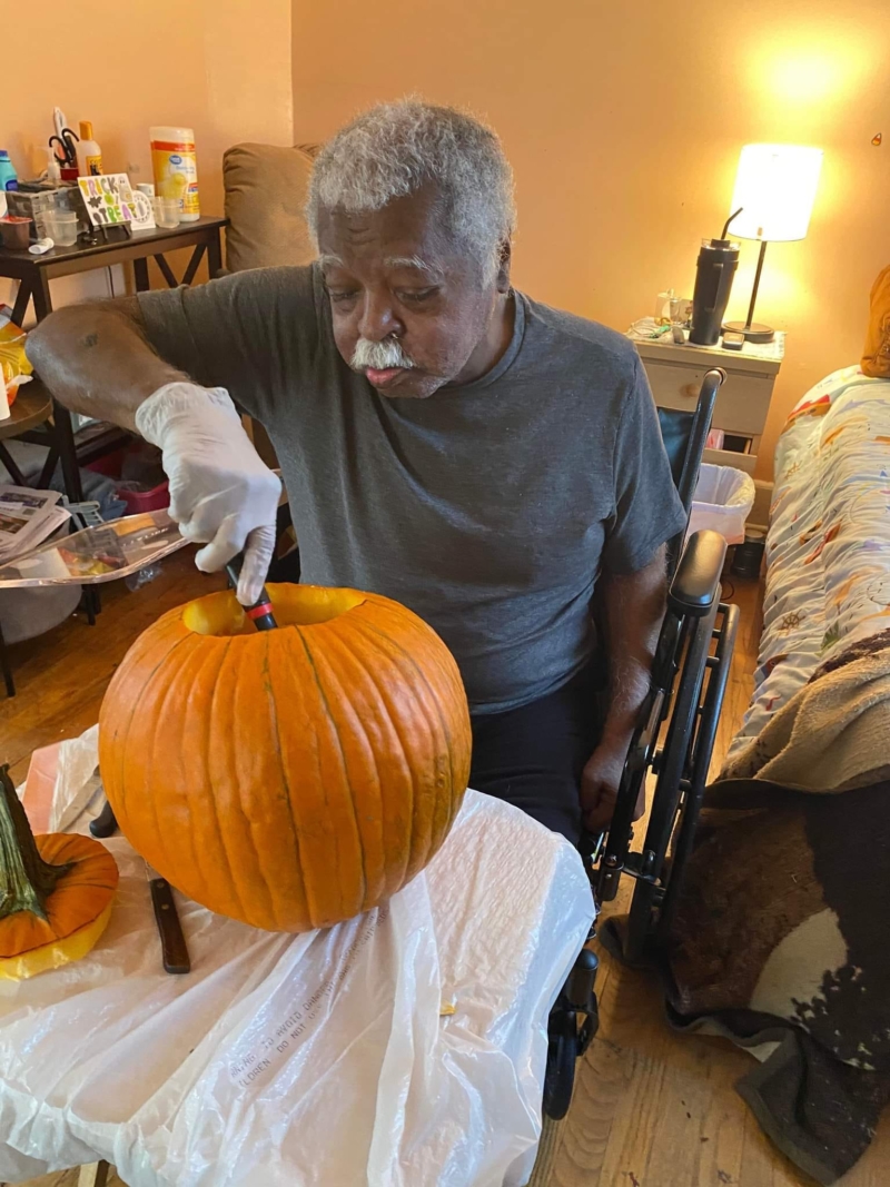 Mr. Reynolds carving his pumpkin.