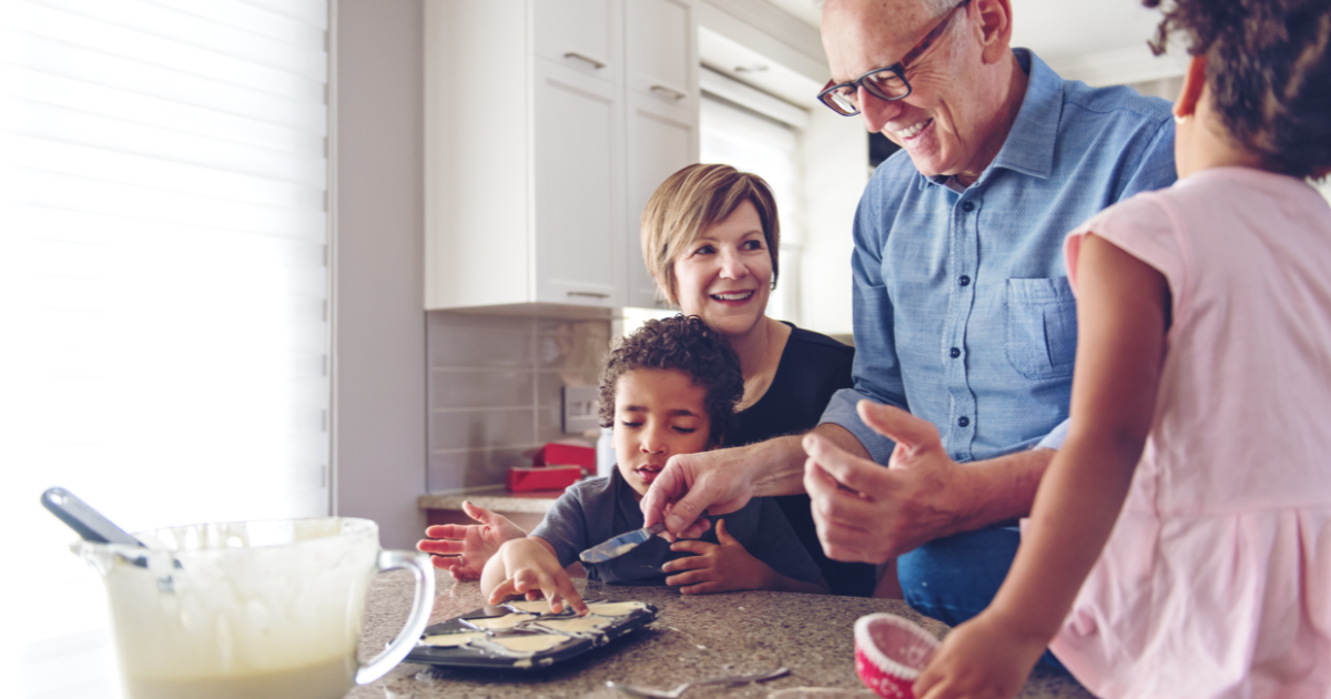Family caregiver assists her children and her elderly father make cookies during the holidays to avoid caregiver stress