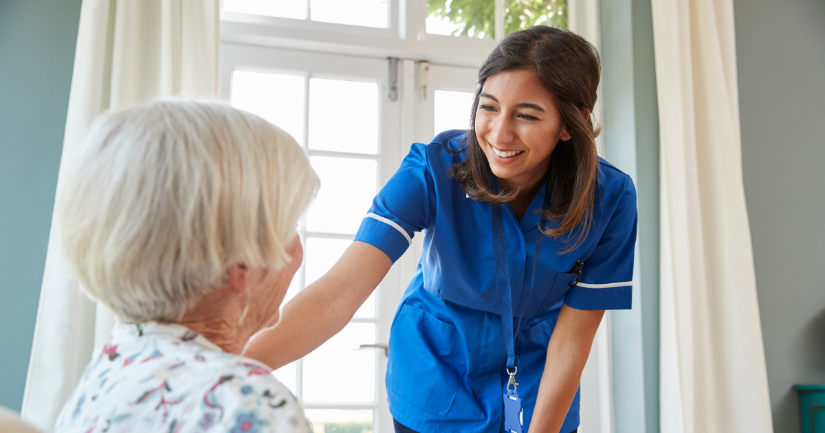 A home health care professional enjoys her job as she help a senior patient.