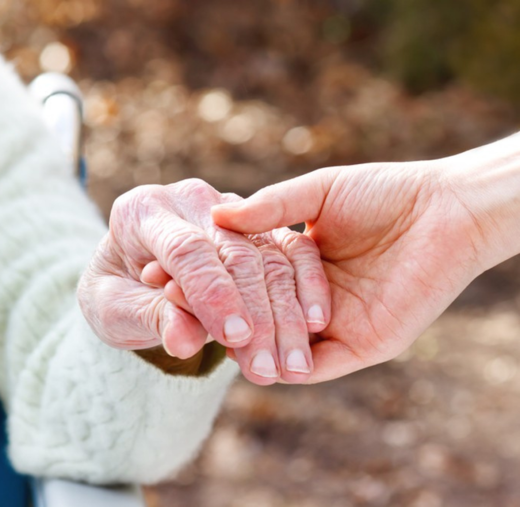 A young hand holds an older one, representing the support that Life Coordinated can bring to those in Mecklenburg County, VA.