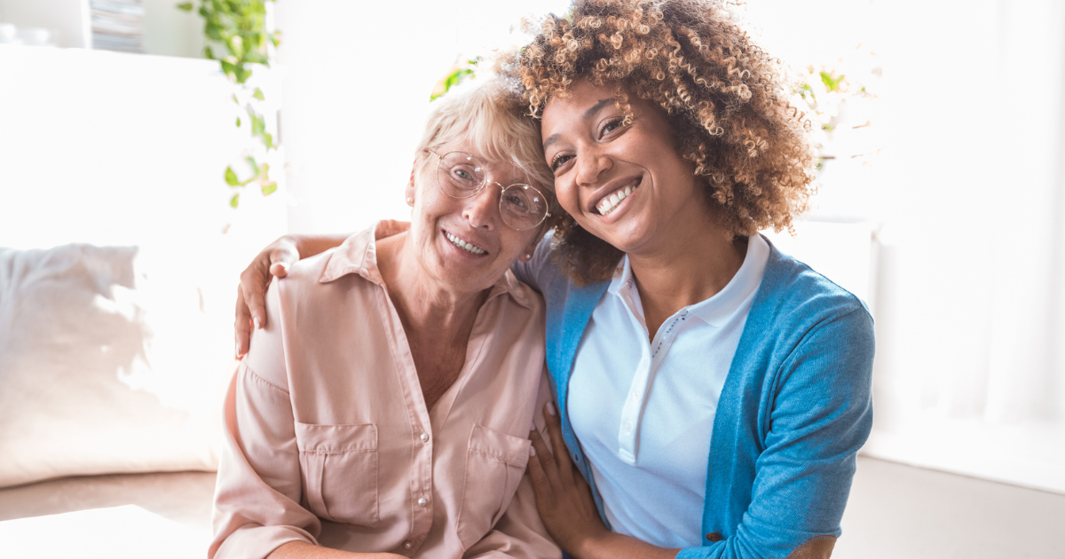 A caregiver hugs a client while both smile, representing the benefits of personal care in Mecklenburg County, VA.