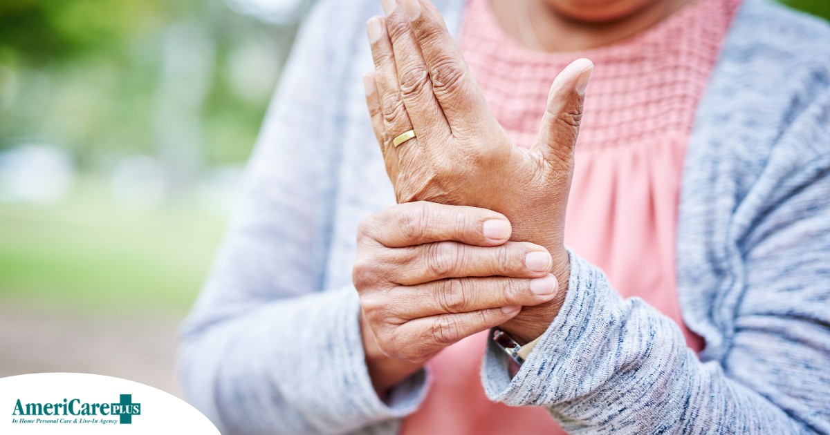 A senior woman holds her hand in pain, representing arthritis and what Arthritis Awareness Month can help with.