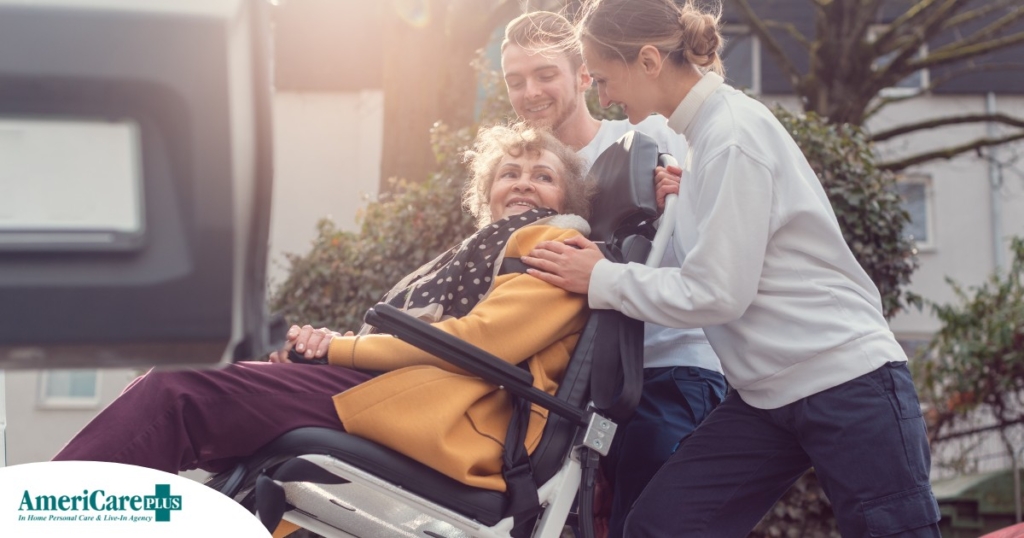 2 caregivers help an older adult get into a vehicle using a ramp, showing how equipment is valuable to professional caregivers when helping older adults.