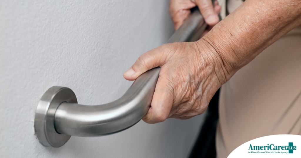 An older adult uses a grab bar representing one of the home modifications that is helpful for fall prevention for elderly adults.