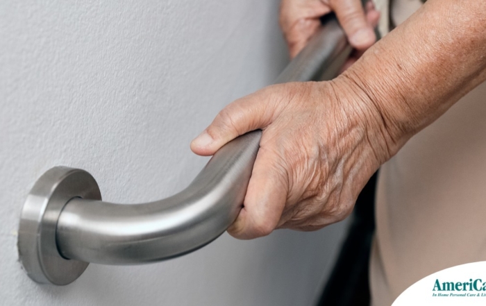 An older adult uses a grab bar representing one of the home modifications that is helpful for fall prevention for elderly adults.