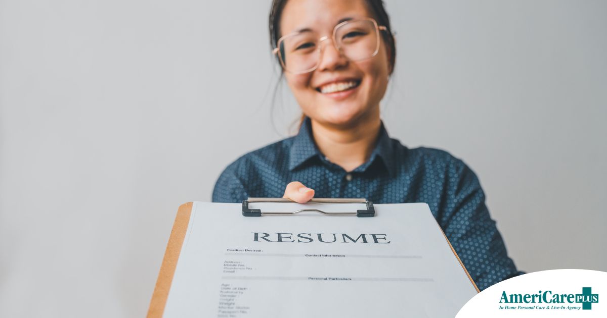 A woman happily hands in a resume, representing a successfully written caregiver resume.